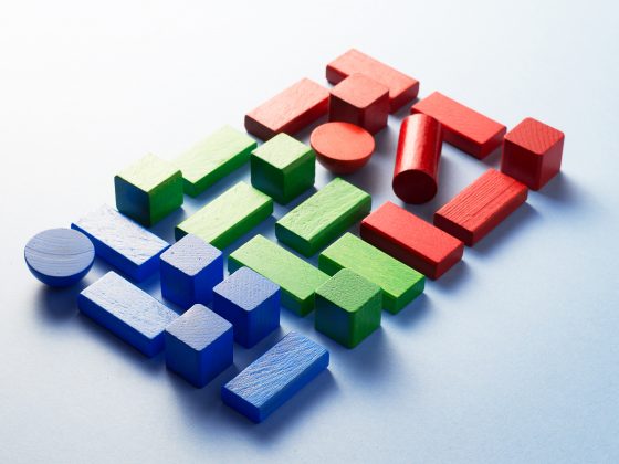 Colorful wooden cubes organized over blue background, top view